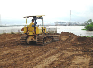 (Hình 1: ảnh máy ủi/xe tải đang san lấp mặt bằng tại công trình)